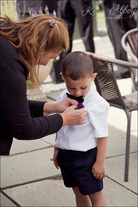 Ring bearer wedding photography boutonniere flower pinning 